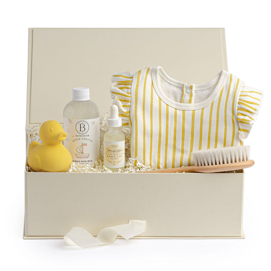 Anna & Amy baby bath gift box filled with yellow rubber duck toy, bubble bath, baby oil, baby brush and matching yellow onesie.